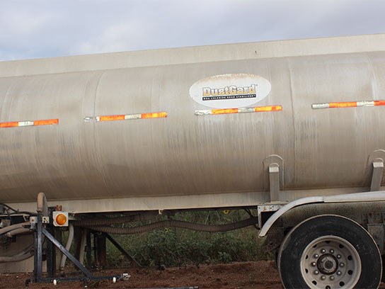 Close up of a big rig container with dust guard written on the side of it.