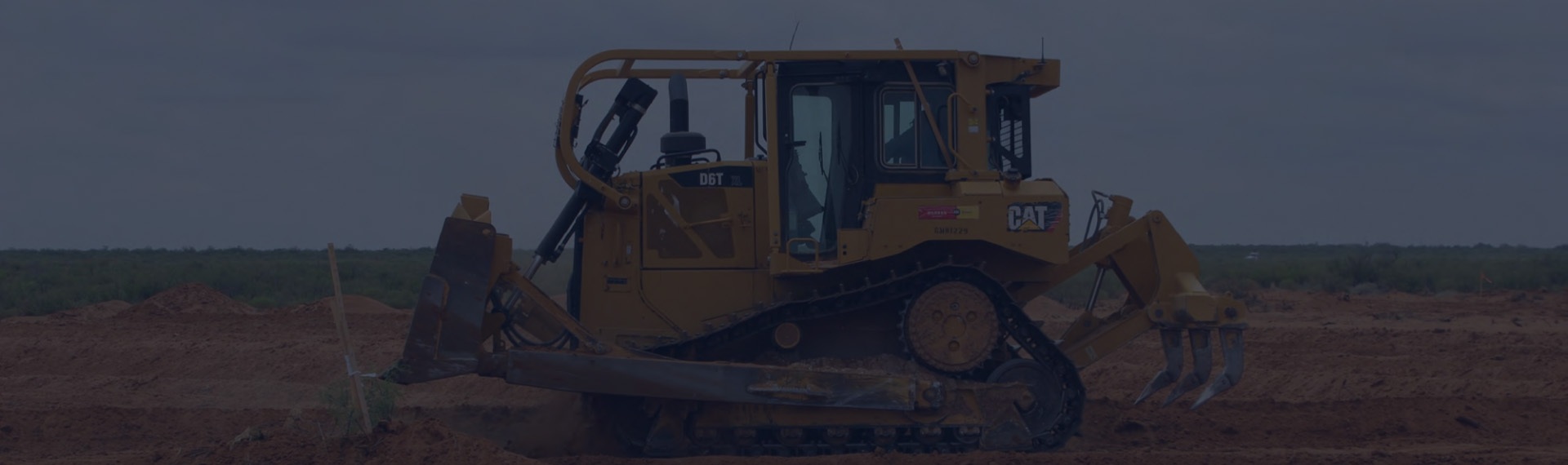 Piece of yellow Cat branded heavy machinery digging in the dirt.